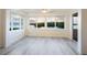 This sunroom features large windows with waterfront views and modern gray plank floors at 2424 Placida Rd # D102, Englewood, FL 34224
