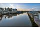 Scenic waterfront view featuring boat docks, calm water, and a building in the background during a beautiful sunset at 2424 Placida Rd # D102, Englewood, FL 34224