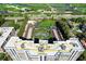 Aerial view of the high-rise condo showcasing tennis courts and a beautiful golf course in the background at 2425 Gulf Of Mexico Dr # 14B, Longboat Key, FL 34228