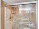 Modern shower featuring glass doors and travertine tile at 2425 Gulf Of Mexico Dr # 14B, Longboat Key, FL 34228