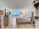 Comfortable bedroom featuring ocean view, tiled floor, and soothing, neutral tones at 2425 Gulf Of Mexico Dr # 14B, Longboat Key, FL 34228