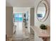 Foyer with travertine floors, ocean view, and decorative shelf with round mirror at 2425 Gulf Of Mexico Dr # 14B, Longboat Key, FL 34228