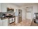Bright kitchen features stainless steel appliances, granite counters, and travertine flooring at 2425 Gulf Of Mexico Dr # 14B, Longboat Key, FL 34228