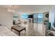 Bright living room with travertine floors, fireplace, ocean view, and white furniture at 2425 Gulf Of Mexico Dr # 14B, Longboat Key, FL 34228