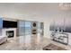 Bright living room with travertine floors, fireplace, ocean view, and white furniture at 2425 Gulf Of Mexico Dr # 14B, Longboat Key, FL 34228