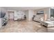 Bright living room with travertine floors, fireplace, ocean view, and white furniture at 2425 Gulf Of Mexico Dr # 14B, Longboat Key, FL 34228