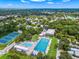 Overhead view of the community pool and tennis courts surrounded by greenery at 2524 Tuttle Way, Sarasota, FL 34239