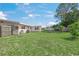 Large backyard with lush green grass, mature trees, and a shed at 2524 Tuttle Way, Sarasota, FL 34239