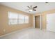 Bright bedroom features tile flooring, ceiling fan, closet, and large window at 2524 Tuttle Way, Sarasota, FL 34239
