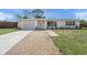 Charming single-story home featuring a well-maintained lawn and inviting brick walkway at 2524 Tuttle Way, Sarasota, FL 34239
