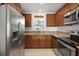 Well-lit kitchen featuring stainless steel appliances and warm, wood-tone cabinetry at 2524 Tuttle Way, Sarasota, FL 34239
