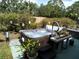 Backyard patio area featuring a luxurious hot tub with potted plants and accessory table at 2787 Jay Pl, Sarasota, FL 34235