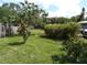 Landscaped backyard featuring lush lawn, privacy fence, and beautiful, mature trees and shrubs at 2787 Jay Pl, Sarasota, FL 34235