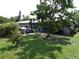 The backyard shows a well maintained lawn, mature trees, and a partially covered patio at 2787 Jay Pl, Sarasota, FL 34235