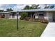Attractive single-story home featuring a metal roof, awning-covered windows and flowering bushes at 2787 Jay Pl, Sarasota, FL 34235