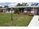 Charming single-story home with a metal roof, a well-manicured lawn, and colorful flowering bushes enhancing its curb appeal at 2787 Jay Pl, Sarasota, FL 34235