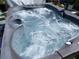 Close-up of a bubbling hot tub with a gray exterior and various jets and controls at 2787 Jay Pl, Sarasota, FL 34235