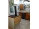 Kitchen with black countertop, stainless steel dishwasher, wooden cabinetry, and tile flooring at 2787 Jay Pl, Sarasota, FL 34235