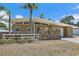 Charming single-story home features a unique stone accent wall, white fence, and a well-maintained yard at 2820 Greenbriar St, Sarasota, FL 34237