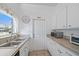 Well-lit kitchen with stainless steel sink, tile countertops, white cabinets, and microwave at 2820 Greenbriar St, Sarasota, FL 34237
