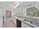 Well-lit kitchen featuring white cabinets, tile countertops, a dishwasher, and a double sink at 2820 Greenbriar St, Sarasota, FL 34237