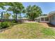 Large backyard features a patio, grassy area, mature trees, and wooden perimeter fence at 304 34Th W St, Bradenton, FL 34205