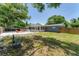 Backyard features a patio, grass, mature trees and bushes, and wooden perimeter fence at 304 34Th W St, Bradenton, FL 34205
