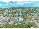 Serene aerial view of a charming neighborhood featuring colorful houses and tropical vegetation near the beautiful ocean at 315 Magnolia Ave, Anna Maria, FL 34216