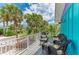 Outdoor seating area on the balcony overlooking the street lined with palm trees at 315 Magnolia Ave, Anna Maria, FL 34216