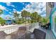 Spacious balcony with outdoor seating offers views of the tropical landscaping at 315 Magnolia Ave, Anna Maria, FL 34216