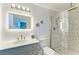 Modern bathroom with white walls, a glass-enclosed shower and a large mirror with good lighting at 315 Magnolia Ave, Anna Maria, FL 34216