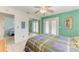 Bedroom with light-colored walls and tile floors, ceiling fan, with a mirror reflecting another bedroom at 315 Magnolia Ave, Anna Maria, FL 34216