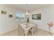 Dining area with a glass-top table, white wicker chairs, and a bright window with beach views at 315 Magnolia Ave, Anna Maria, FL 34216