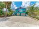Charming coastal home with vibrant turquoise and purple exterior, balcony, and a two-car garage at 315 Magnolia Ave, Anna Maria, FL 34216