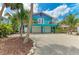 Charming coastal home with vibrant turquoise and purple exterior, balcony, and a two-car garage at 315 Magnolia Ave, Anna Maria, FL 34216