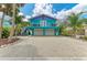 Charming coastal home with vibrant turquoise and purple exterior, balcony, and a two-car garage at 315 Magnolia Ave, Anna Maria, FL 34216
