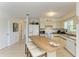 Bright eat-in kitchen featuring tiled floors, white appliances and cabinetry, and a center island with barstool seating at 315 Magnolia Ave, Anna Maria, FL 34216