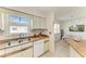 Kitchen sink with a large window, with views of the dining room with a wicker table set at 315 Magnolia Ave, Anna Maria, FL 34216