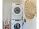 Laundry room with stackable washer and dryer, white utility sink, and storage space; practical and functional at 315 Magnolia Ave, Anna Maria, FL 34216