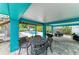 Charming outdoor living space with dining and seating, offering a relaxing view of the lush backyard at 315 Magnolia Ave, Anna Maria, FL 34216