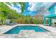 Gorgeous backyard featuring a sparkling pool, lush landscaping, and comfortable seating for relaxation at 315 Magnolia Ave, Anna Maria, FL 34216