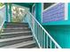 Exterior stairway with white railing, leading up to the main living space of the turquoise beach house at 315 Magnolia Ave, Anna Maria, FL 34216