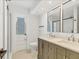 Bathroom featuring double sinks, modern fixtures, a decorative door and stylish mirrors at 3328 Kingswood Dr, Sarasota, FL 34232