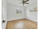 Bright bedroom featuring hardwood floors, ceiling fan, and natural light from two windows at 3328 Kingswood Dr, Sarasota, FL 34232