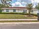 Charming single-Gathering home with manicured front yard featuring lush greenery and a well maintained lawn at 3328 Kingswood Dr, Sarasota, FL 34232