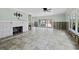 Spacious living room with fireplace, tile floors, and sliding glass doors to the enclosed patio at 335 Arthur Dr, Sarasota, FL 34236