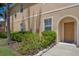 The front entrance of the home with flowering bushes and a stone border at 3402 Parkridge Cir, Sarasota, FL 34243