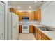Functional kitchen featuring white appliances, wood cabinets, and tiled floors at 3402 Parkridge Cir, Sarasota, FL 34243
