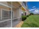 Screened patio with view of the building's side, lawn, and lake at 3402 Parkridge Cir, Sarasota, FL 34243