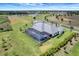 Aerial shot of a home with a screened pool, outbuilding, a well-manicured lawn, and sprawling trees at 3574 Recurve Cir, Sarasota, FL 34240